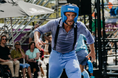 Een atleet in beschermende kleding en een helm, met een sportieve uitstraling, tijdens een evenement.