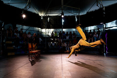 Een voorstelling met twee performers in een donkere theatertent.