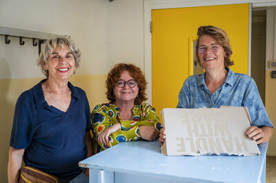 Drie dames staan naast elkaar in een gang.