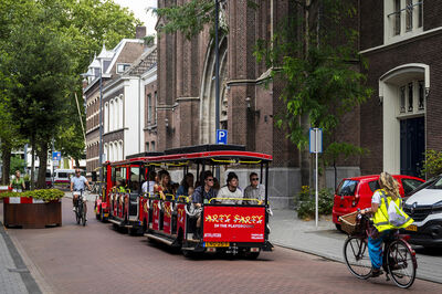 Een toeristentreintje rijd door een straat in Den Bosch.