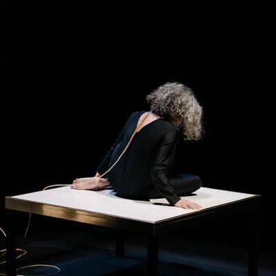 Een vrouw zit op een lage tafel.