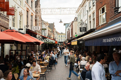 Een straat met oude huizen en terrassen.