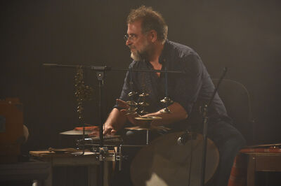 Een percussionist met instrumenten op een donker podium.
