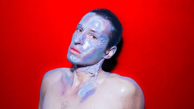 Foto van persoon met holografische make-up over hun hele gezicht.