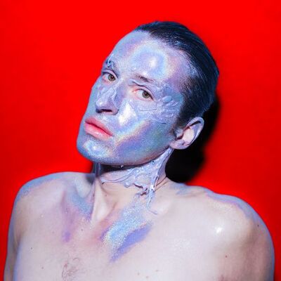 Foto van persoon met holografische make-up over hun hele gezicht.