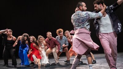Een groep dansers voert een energieke choreografie uit op een podium.