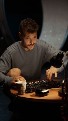 Iemand speelt aan een laag tafeltje op een mini-keyboard.