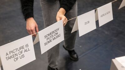 Witte vellen papier met verschillende teksten erop worden over een strak gespannen touw gehangen.