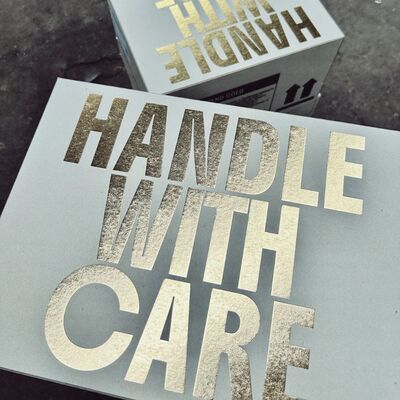 Kartonnen dozen met hierop de tekst: "Handle with Care".