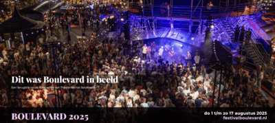 Drukke straat tijdens een evenement met een groot publiek en een podium op de achtergrond, genoteerd als "Boulevard 2023".