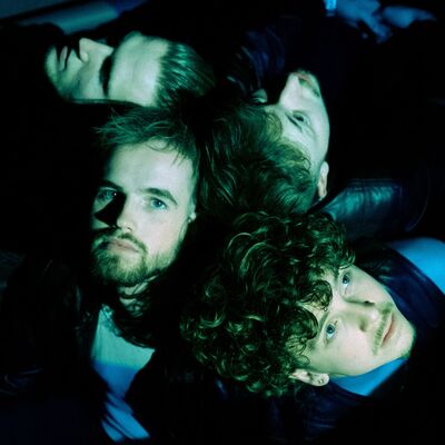 Een bandfoto van vier mensen.