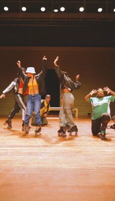 Een groep van zes mensen op rolschaatsen in verschillende vrolijke poses.