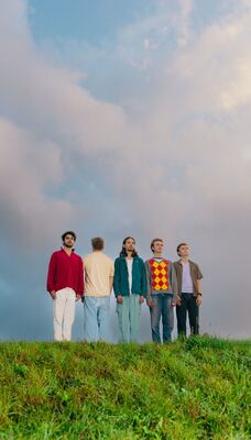 Een bandfoto van 5 mensen.